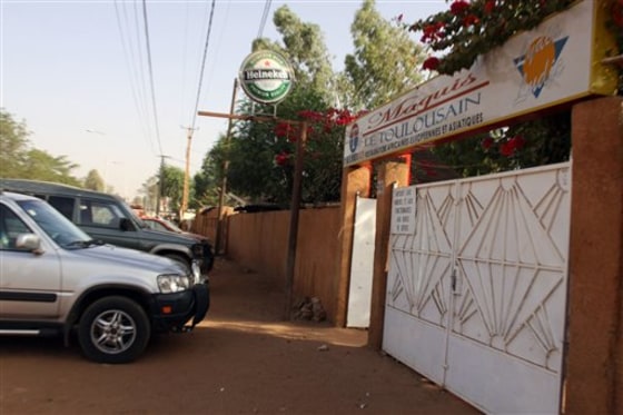 Cars sit parked outside the front gate of the Toulousain restaurant, where witnesses say two French nationals were kidnapped at gunpoint late Friday by turbaned men, in Niamey, Niger. A witness was dining inside when he says two men walked in, pulled out guns and told the French citizens to follow them. Outside, he says, two more men were waiting and they forced them into a truck and sped off. 